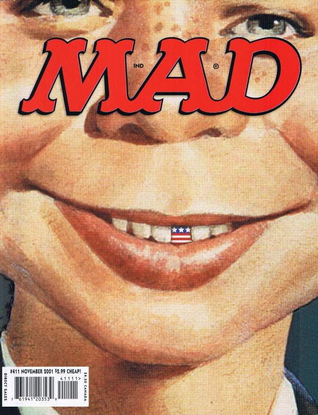 Extrem herangezoomtes Gesicht von Alfred E. Neuman, dessen markante Zahnlücke durch eine amerikanische Flagge gefüllt ist. Erschienen als Cover der US-Ausgabe MAD #411.