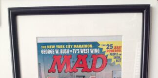 Gerahmtes, unveröffentlichtes Titelbild der US-Ausgabe MAD #411 von John Caldwell. Alfred E. Neuman rennt beim New York Marathon lachend durch ein Polizei-Absperrband an einem Tatort.