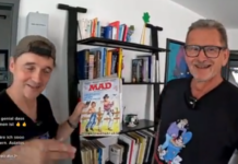 Neues Interview mit dem legendären MAD-Zeichner Ivica Astalos Paddy und der deutsche MAD-Zeichner Ivica Astalos stehen nebeneinander vor einem Regal. Paddy hält lächelnd ein klassisches MAD-Magazin in die Kamera.
