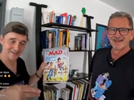 Paddy und der deutsche MAD-Zeichner Ivica Astalos stehen nebeneinander vor einem Regal. Paddy hält lächelnd ein klassisches MAD-Magazin in die Kamera.