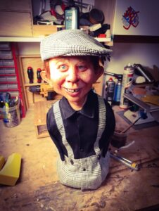 Fertige, lebensnahe Alfred E. Neuman Büste von Pierre Schrader mit Schiebermütze und Hosenträgern im Hahnentritt-Muster in der Werkstatt.