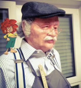 Lebensgroße Silikonbüste von Meister Eder (Gustl Bayrhammer) mit Brille, Schiebermütze und gezeichnetem Pumuckl auf der Schulter, gefertigt von Bildhauer Pierre Schrader.